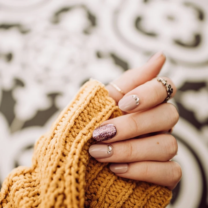 Manicure nude con dettaglio glitter